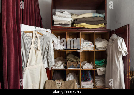 Wäscheschrank mit typischen Bettwäsche und Kleidung aus der Viktorianischen Zeit, arbeitshaus Museum, Ripon, North Yorkshire, Großbritannien Stockfoto