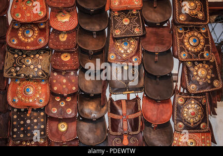 Marokkanische Lederwaren und Taschen mit Metall Verzierungen an einem Souk oder Markt durch die Gerberei in Fes, Marokko. Stockfoto