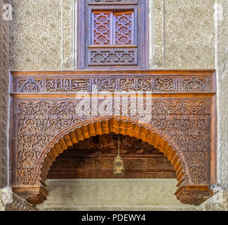 Marokkanische Zedernholz und geschnitzten Gips Arabesque arch im 14. Jahrhundert El Attarine Medersa in Fez, Marokko Stockfoto