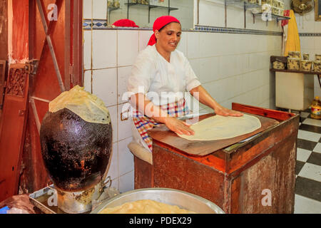 Fes, Marokko - 11. Mai 2013: Frau, die marokkanische Crepes in der Souk in der Medina von Fez Stockfoto