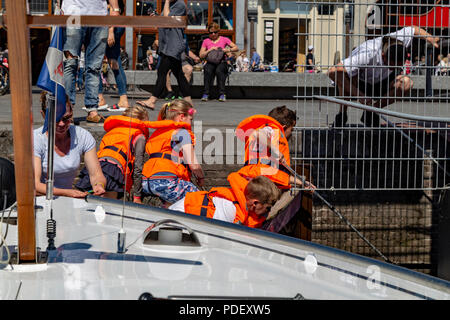 Schule Kinder lernen und Reinigung der Kanäle in Amsterdam, Niederlande Stockfoto