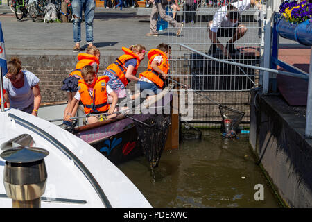 Schule Kinder lernen und Reinigung der Kanäle in Amsterdam, Niederlande Stockfoto