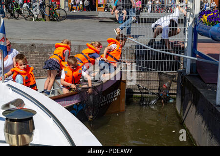 Schule Kinder lernen und Reinigung der Kanäle in Amsterdam, Niederlande Stockfoto