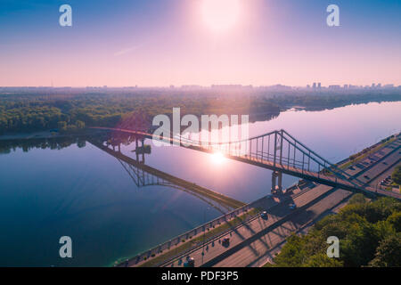 Stadt Kiew mit einem herrlichen Morgenhimmel. Fußgängerbrücke. Am linken Ufer des Dnjepr. Bird's-eye. Sonnenaufgang über der Stadt Stockfoto