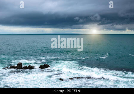 Gewitterwolken über dem Meer bei Sonnenuntergang. Stockfoto