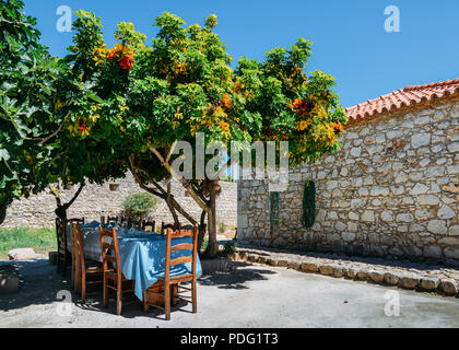 Esstisch aus Holz liegt in einem üppigen Garten, in Sesimbra, Setubal, Portugal Provinz erfasst Stockfoto