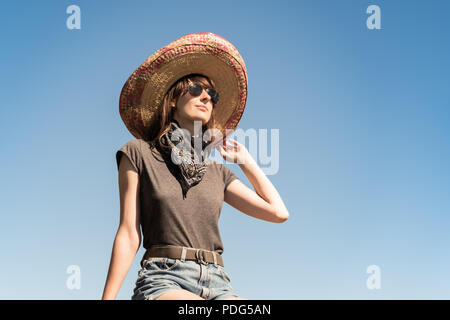 Junge schöne Mädchen in Sombrero und bandana verkleidet als Bandit der Gangster. Weibliche Person im traditionellen mexikanischen Hut posiert wie Mexiko festliche Symbo Stockfoto