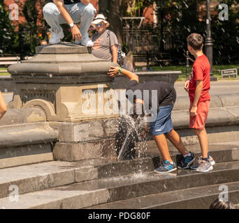 New Yorker und Besucher in der Brunnen im Washington Square Park in Greenwich Village in New York am Mittwoch, Frolic, 8. August 2018. Hohe Luftfeuchtigkeit und bratenen Temperaturen garantieren eine unbequeme Tag in New York als Wärme Beratung ist. Trotz der Stürme vorhergesagt durch Mittwoch abend die Hitze und die Feuchtigkeit wird den Rest der Woche bleiben. (Â© Richard B. Levine) Stockfoto