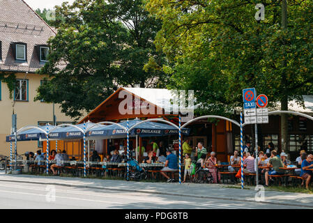 München, Deutschland - 28. Juli 2018: Die ÜBERFÜLLTEN bayerischen Biergarten im Sommer mit viel Bier und Snacks serviert. Stockfoto