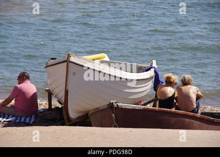 Die traditionellen kleinen Ruderboote Strände in Sidmouth brechen Wasser. East Devon, Großbritannien. August, 2018. Stockfoto