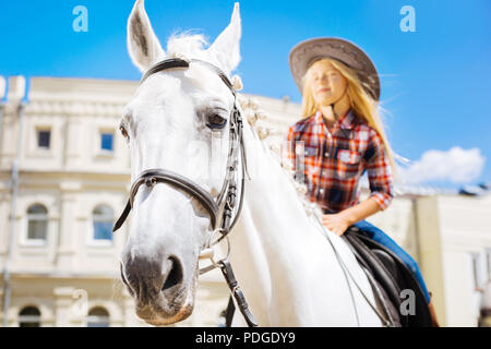 White Racing Pferd stehend unterwürfig mit Mädchen auf ihn Stockfoto