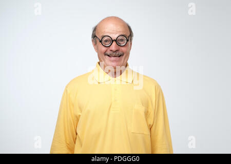 Porträt eines lustigen reifer Mann im Kreis Brille mit Kamera auf grauem Hintergrund Stockfoto