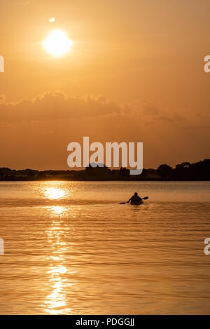 Kajakfahren auf dem See bei Sonnenuntergang Stockfoto