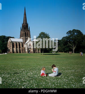 Clumber Park, Nottinghamshire - Kinder spielen in der Sonne mit der Kirche. Stockfoto