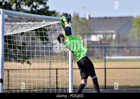 Keeper Auslenkung ein Schuß, der in der Kugel weg Zurückprallen der Querstrebe geführt. Stockfoto