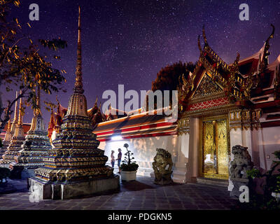 Junges Paar in der Buddhistischen Tempelanlage Wat Pho in Bangkok an der magischen Nacht Sternenhimmel im Hintergrund in Thailand Stockfoto