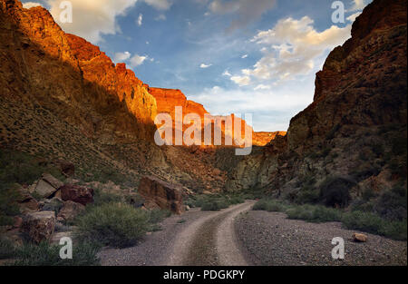 Orange Felsen und Straße bei charyn Canyon bei Sonnenuntergang in Kazakhsthan Stockfoto