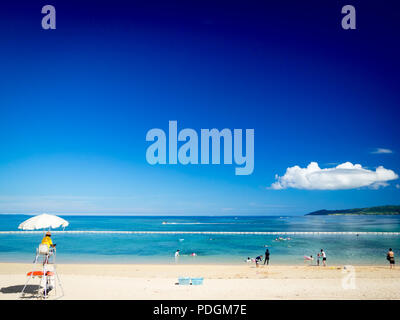 Ein Rettungsschwimmer und Badegäste am Strand auf Fusaki Ishigaki Island (Ishigaki-jima), yaeyama Inseln, in der Präfektur Okinawa, Japan. Stockfoto