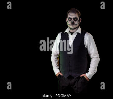 Porträt von einem gut gekleideten Mann mit Totenkopf Make-up. Horror und Halloween Motto, mit Bühnenbeleuchtung und Effekte Schuß Stockfoto