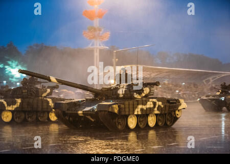 Minsk, Weißrussland - Juni 28, 2017: T-72 B Tank bewegt sich auf der Straße während der Probe von Parafe vor der Feier der Tag der Unabhängigkeit von Belarus. Abends regnerisch Stockfoto