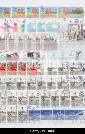 Bunte alte Deutsche gestempelten Briefmarken in einen Stempel album Stockfoto