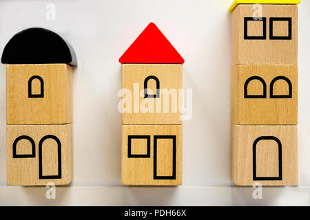 Kleines Spielzeug Häuser aus Holzklötzen mit bemalten Fenstern. Rote und schwarze Dreiecke auf die Dächer. Stockfoto
