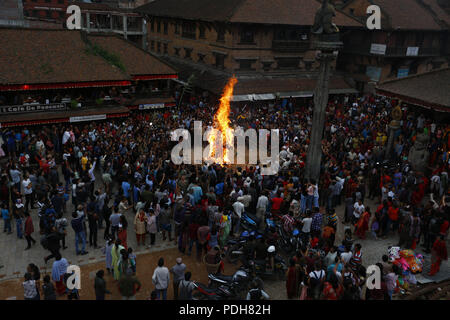 Bhaktapur, Nepal. 9 Aug, 2018. Devotees brennen ein Stroh Bildnis des mythischen Daemon Ghanta Karna während der Feierlichkeiten der Hindu festival Gathemangal in Bhaktapur, Nepal am Donnerstag, August 09, 2018. Nach Mythen Es wird angenommen, dass durch die Verbrennung der Dämon befreien, böse Geister und Krankheiten von Kindern. Credit: Skanda Gautam/ZUMA Draht/Alamy leben Nachrichten Stockfoto