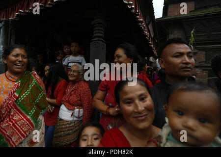 Bhaktapur, Nepal. 9 Aug, 2018. Nepalesische Volk sitzen um einen Strohhalm Bildnis des mythischen Daemon' Ghanta Karna' verbrannt wird während der Feierlichkeiten der Hindu festival Gathemangal in Bhaktapur, am Stadtrand von Kathmandu, Nepal, 01. August 2016. Einheimische Bhaktapur für das Festival versammelt, in dem Glauben, dass brennendes Stroh Bildnisse des Daemon wehrt Krankheiten von Kindern. Credit: Skanda Gautam/ZUMA Draht/Alamy leben Nachrichten Stockfoto