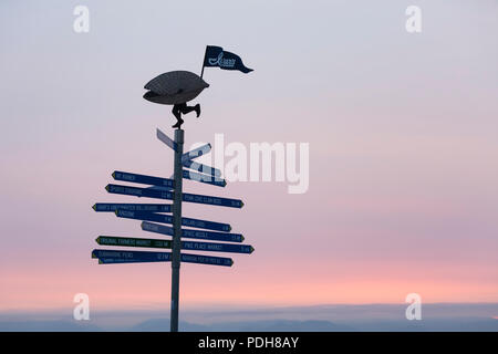 Seattle, Washington, USA. 8. August 2018. Ein mileage Marker für Touristen am Pier 54. In der Ferne, Rauch steigt aus dem Ahorn Feuer in der Nähe von Hamma Hamma verdecken die Olympischen Berge über Elliott Bay. Waldbrände brennen in der Region sowie in Kalifornien und Oregon haben beeinträchtigt die Qualität der Luft im Puget Sound auf ein moderates Niveau. Credit: Paul Christian Gordon/Alamy leben Nachrichten Stockfoto