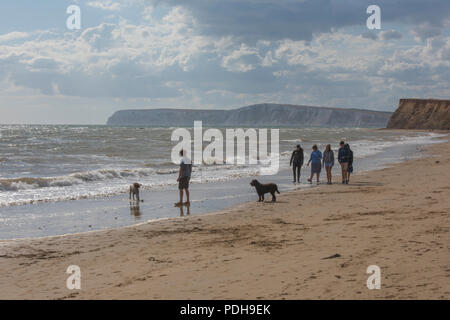 Compton Bay auf der Isle of Wight, Großbritannien. 9. August 2018. Nach einer Hitzewelle, Kühler verunsichert seeminglyendless consition mehr im Einklang mit dem jahreszeitlichen Durchschnitt Temperaturen zum Strand von Compton Bay auf der Isle of Wight zurück. Familien und Freund zu Fuß am Strand und nutzen Sie die kühleren Temperaturen im Sommer und ungeklärten Bedingungen mit einer steifen Brise. Quelle: Steve Hawkins Fotografie/Alamy leben Nachrichten Stockfoto