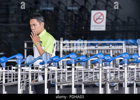 Sepang, Kuala Lumpur, Malaysia. 9 Aug, 2018. Ein Mann gesehen Rauchen am Kuala Lumpur International Airport Kuala Lumpur International Airport auch als KLIA bekannt ist der Malaysische internationalen Flughafen und es ist der 23 größten und verkehrsreichsten Flughafen der Welt durch den gesamten Personenverkehr. KLIA wurde am 27. Juni 1998 Von den 10 Yang di-Pertuan Agong, Tuanku Ja'afar von Negeri Sembilan eingeweiht. Credit: Faris Hadziq/SOPA Images/ZUMA Draht/Alamy leben Nachrichten Stockfoto