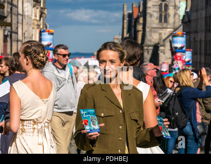 Edinburgh, Schottland, Großbritannien. 9. August 2018. Edinburgh Fringe Festival, Royal Mile, Edinburgh, Schottland, Vereinigtes Königreich. An einem sonnigen Festival Tag der Jungfrau Geld gesponsert Street Festival mit Menschen und fringe Darsteller verpackt ist. Eine Gruppe von hübschen jungen Frauen im Zweiten Weltkrieg Kostüme gekleidet hand Flyer für Ihre Fringe Show namens Liebe Lucy Stockfoto