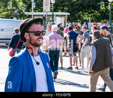 Edinburgh, Schottland, Großbritannien. 9. August 2018. Edinburgh Fringe Festival, Edinburgh, Schottland, Vereinigtes Königreich. An einem sonnigen Festival Tag der Innenstadt mit Menschen und fringe Darsteller auf dem Damm ist. Eine Street Performer wartet seine Umdrehung auf dem Damm zu nehmen Stockfoto