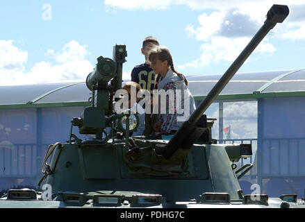 Pskow, Russland. 07 Aug, 2018. Kinder klettern auf der Internationalen Armee Spiele auf dem Trainingsgelände des 76th Russische Fallschirmjäger Division in der Nähe von Pskow auf einen gepanzerten Infanterie Panzer der russischen Armee. Mannschaften aus 32 Nationen konkurrieren gegeneinander in die Olympischen Spiele der militärischen Fähigkeiten. (Auf dpa' Flugzeuge Dart und Tank Biathlon: Russlands große Armee Wettbewerb" von 10.08.2018) Credit: Friedemann Kohler/dpa/Alamy leben Nachrichten Stockfoto