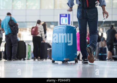 Frankfurt am Main, Deutschland. 10 Aug, 2018. Ein Passagier gehen mit einem Koffer im Terminal 2 des Frankfurter Flughafens. Credit: Silas Stein/dpa/Alamy leben Nachrichten Stockfoto