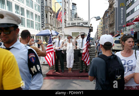 Berlin, Deutschland. 09 Aug, 2018. Am Checkpoint Charlie, dem früheren Grenzübergang zwischen West- und Ost-Berlin, Touristen sind mit Schauspielern, die in Uniformen der US-Soldaten vor einer rekonstruierten historischen Allied Border House fotografiert. Quelle: Wolfgang Kumm/dpa/Alamy leben Nachrichten Stockfoto