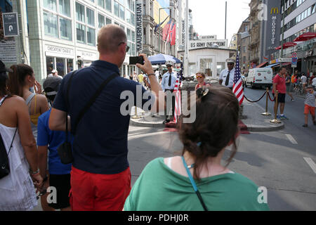 Berlin, Deutschland. 09 Aug, 2018. Touristen nehmen Bilder von Akteuren in Uniformen der US-Soldaten vor einer rekonstruierten historischen Allied Grenze Haus am Checkpoint Charlie, dem früheren Grenzübergang zwischen West- und Ost-Berlin. Quelle: Wolfgang Kumm/dpa/Alamy leben Nachrichten Stockfoto