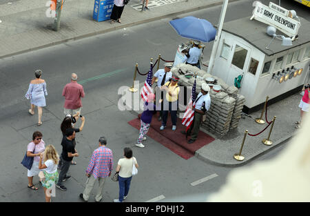 Berlin, Deutschland. 09 Aug, 2018. Touristen nehmen Bilder von Akteuren in Uniformen der US-Soldaten vor einer rekonstruierten historischen Allied Grenze Haus am Checkpoint Charlie, dem früheren Grenzübergang zwischen West- und Ost-Berlin. Quelle: Wolfgang Kumm/dpa/Alamy leben Nachrichten Stockfoto