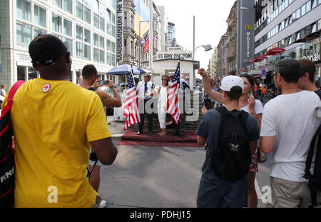 Berlin, Deutschland. 09 Aug, 2018. Touristen nehmen Bilder von Akteuren in Uniformen der US-Soldaten vor einer rekonstruierten historischen Allied Grenze Haus am Checkpoint Charlie, dem früheren Grenzübergang zwischen West- und Ost-Berlin. Quelle: Wolfgang Kumm/dpa/Alamy leben Nachrichten Stockfoto