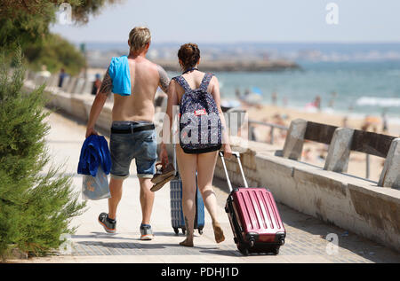 Palma de Mallorca, Spanien. 09 Aug, 2018. Touristen zu Fuß entlang der Can Pere Antoni Strand mit ihrem Gepäck. Credit: Clara Margais/dpa/Alamy leben Nachrichten Stockfoto