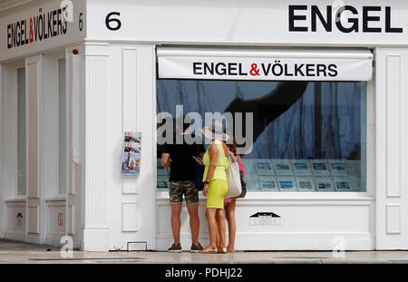 Palma de Mallorca, Spanien. 09 Aug, 2018. Touristen, die auf der Suche am Schaufenster der Immobilienunternehmen Engel & Voelkers am Meer. Credit: Clara Margais/dpa/Alamy leben Nachrichten Stockfoto