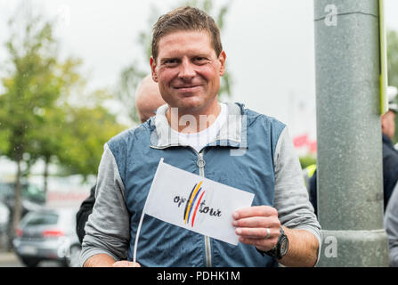 Der ehemalige Radprofi Jan Ullrich steht auf dem Bürgersteig, eine Fahne mit der Aufschrift "on tour" und wartet mit Ventilatoren für die Ankunft der Peloton in Korschenbroich, Deutschland, während der Dusseldorf-Luttich Ausdehnung, die 2. Etappe der Tour de France, Teil der UCI World Tour, 02. Juli 2017. Foto: Guido Kirchner/dpa | Verwendung weltweit Stockfoto