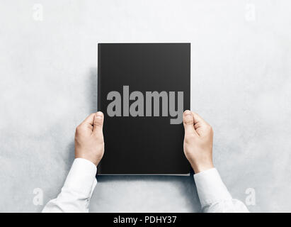 Hand, schwarz Magazin mit Abdeckung mockup. Arm shirt halten Journal klare Vorlage mock up. A4 Buch softcover Oberflächengestaltung. Taschenbuch drucken Anzeigen. Notebook geschlossen mit. Stockfoto