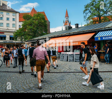 München, Deutschland - 29. Juli 2018: Traditionell gekleidete Bayerischen Männer an einem open air Biergarten im Viktualienmarkt in der Altstadt von München, Ge Stockfoto