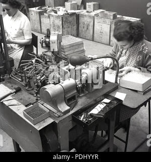 1950, historische, weiblichen Arbeiter in einer Fabrik. Die industriellen Bedürfnisse von WW2 sah, die Beschäftigung von Frauen zu tun factory Jobs zuvor von Männern und in der post-Kriegsjahre in Großbritannien, dies fortgesetzt. Stockfoto