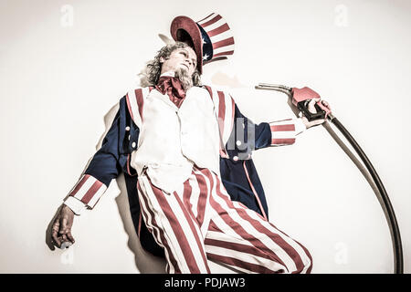 Uncle Sam tot neben einem Benzin pumpe Düse. Zu Öl-/fossilen Brennstoffen abhängig. Stockfoto