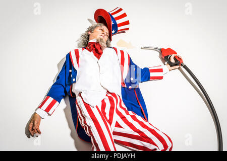 Uncle Sam tot neben einem Benzin pumpe Düse. Zu Öl-/fossilen Brennstoffen abhängig. Stockfoto
