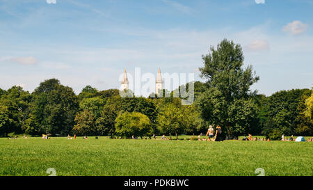 München, Deutschland - 29. Juli 2018: die Münchner Skyline vom Englischen Garten, Deutsch. Einheimische, Touristen und einem warmen Sommertag im Park Stockfoto