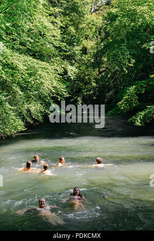 München, Deutschland - 29. Juli 2018: Die Schwimmer auf den sich schnell bewegenden Eisbach, ein kleiner Mann -, die 2 km lange schnelle Stromschnellen im Englischen Garten, München Stockfoto