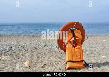 Rettungswesten und Rettungsring am Strand. Stockfoto